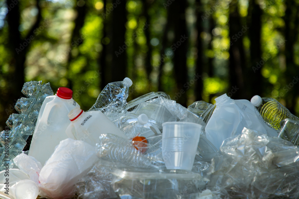 Fototapeta premium Waste trash in green nature. Waste in park. Environment and trash concept. Trash for eco recycling. Trash in nature. Plastic in pollution. Plastic and waste. Plastic for recycling.