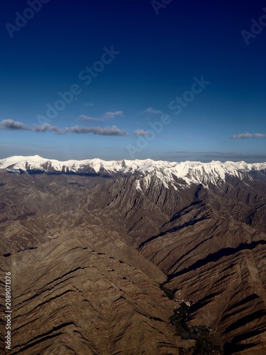 Natural contrast of icy mountain summits, dry rocky slopes