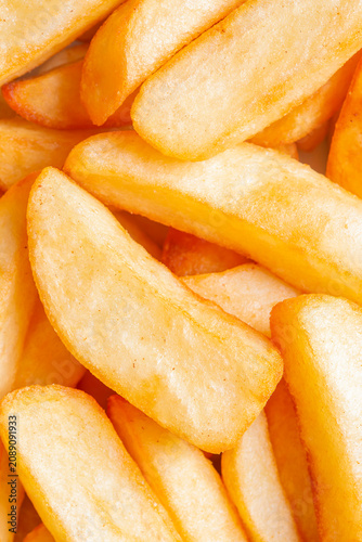 Tripled cooked fried chips background backdrop. Traditional British fried food concept.
