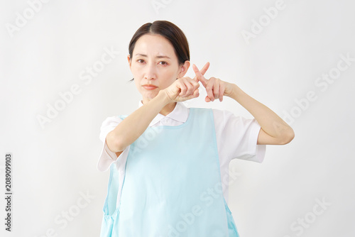Foto 介護士女性　ばつ印のポーズ　白背景