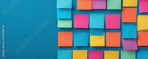 Colorful sticky notes arranged on blue background with copy space for text reminders and office planning tasks for efficient project management