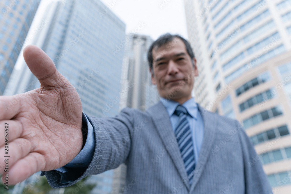 Fototapeta premium 手を差し出す日本人ビジネスマンの信頼イメージ