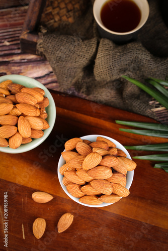 Tableau sur toile Roasted Almonds with Tea on Wooden Table
