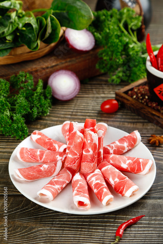 Raw Lamb Meat Rolls on Plate with Fresh Vegetables for Hot Pot Cooking