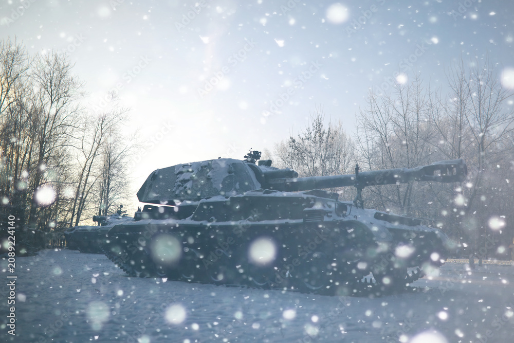 Naklejka premium Military tank in a row. Battle tank in the snow on the roadside of highway. War in Ukraine in winter.
