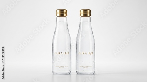 Glass water bottles with gold caps in clean studio lighting for beverage advertising.
