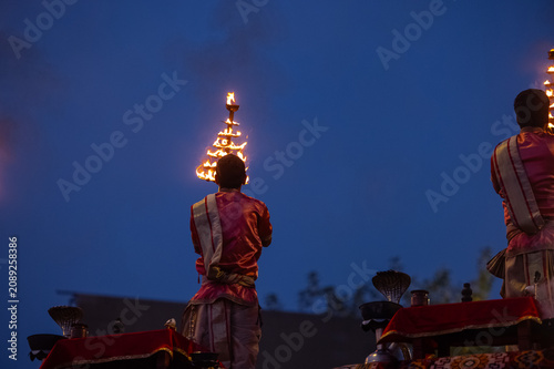 Ganga aarti, Portrait of an young unidentified male priest performing holy river ganga early morning aarti at assi ghat in traditional dress with hindu rituals.