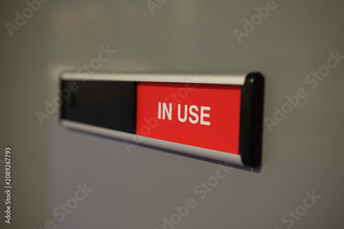 Принти на полотні Meeting room occupancy sign displaying in use status mounted on office wall for