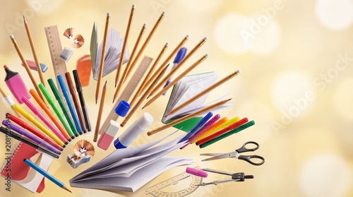 Colorful school supplies and stationery flying on bokeh background, creative education concept with pencils and notebooks, back to school artistic layout
