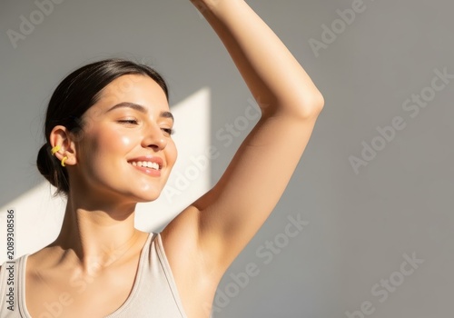 Woman smiling with clean underarm, showcasing smooth skin and confidence in natural light