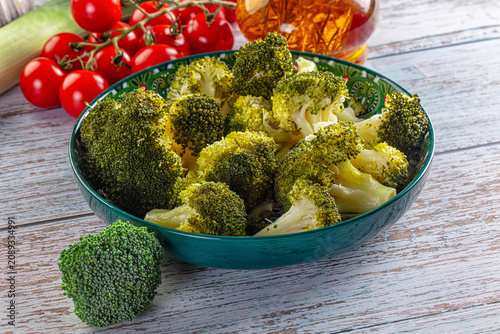 Canvastavla Fresh broccoli florets in patterned bowl with cherry tomatoes and leek on rustic