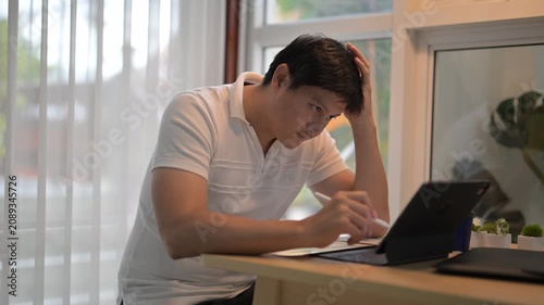 Asian freelancer working and thinking at home