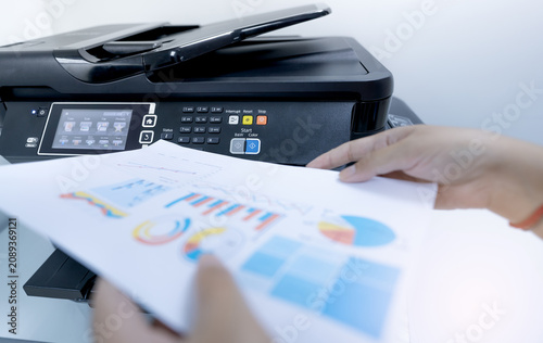 фотографія Office worker prints paper on multifunction laser printer