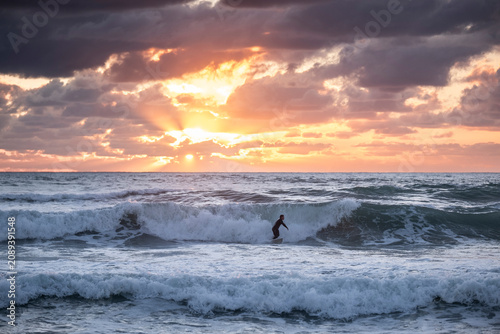 Surfeur dans les vagues couché de soleil