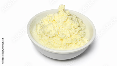 Fotografie Freshly churned white butter rests in bowl with buttermilk pooled at bottom
