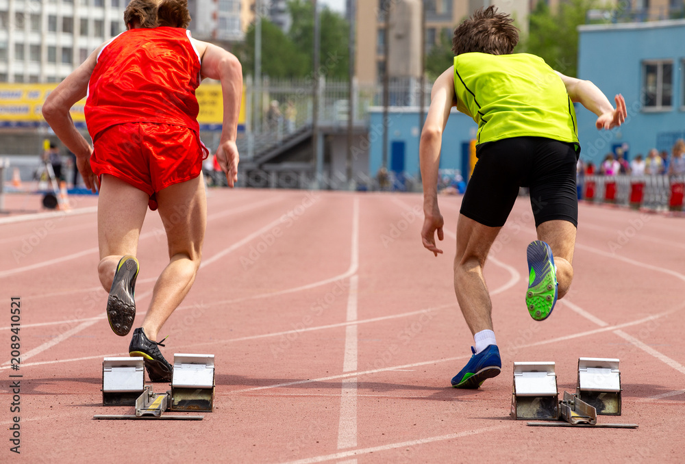 Naklejka premium Two athletes start running 100-meter race during track and field event
