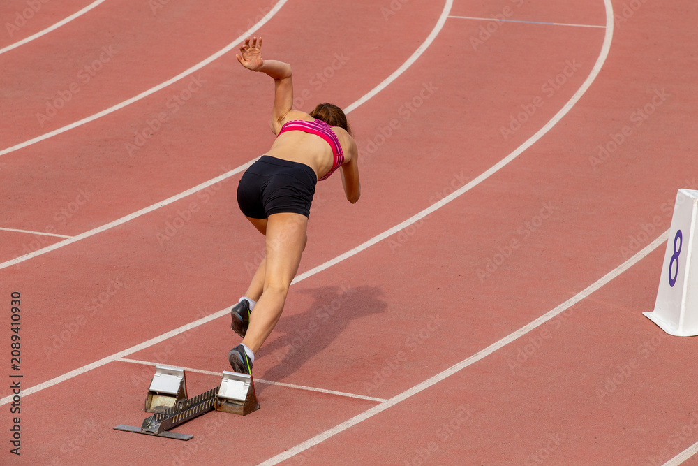 Obraz premium Start female athlete in 400-meter race during track and field event