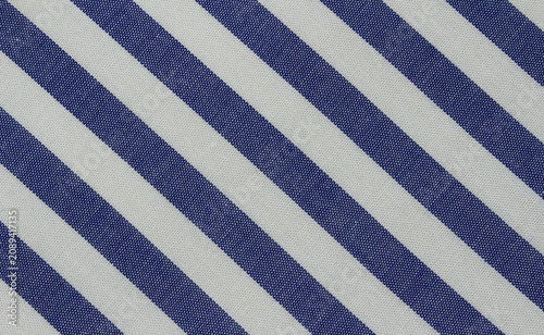 Texture of classic blue and white diagonal striped cotton cloth. Close up of blue striped fabric background.