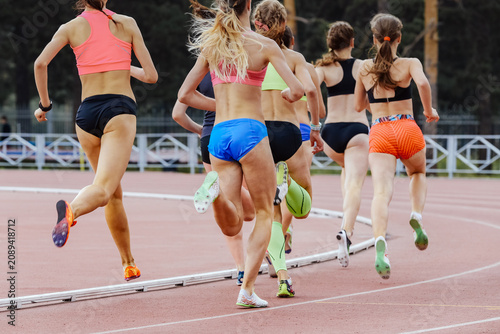 Group female athletes running  800-meter race at athletics competition