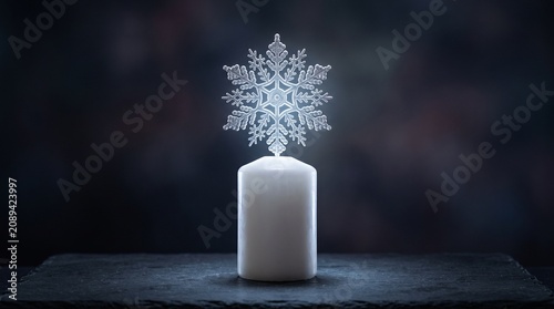 Candle with a glowing snowflake as its flame, concept of winter wonder and purity