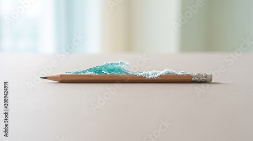 Pencil with a miniature ocean wave rising from its shaft, concept of creativity and the power of imagination