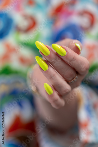 Foto Female hand with long nails and neon yellow green manicure