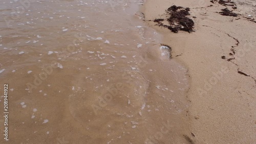 Waves wash away the traces of bare feet on the sand, the concept of rest and relaxation