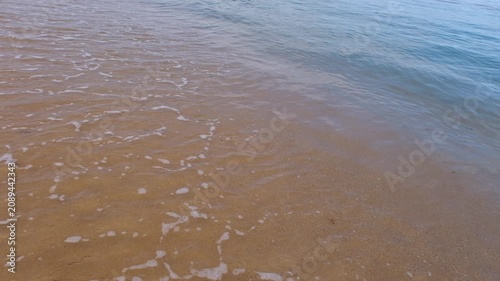 Transparent waves rolling onto a sandy beach, the concept of rest and relaxation