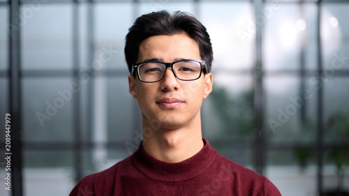Foto Handsome young Asian man smiling in a red sweatshirt