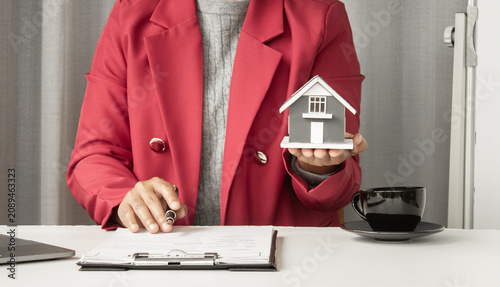 Cuadro en lienzo The real estate agent explains the business contract, holding a model house, a s