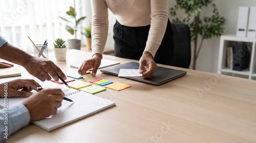 Coworkers Collaborating on Business Project with Sticky Notes and Laptop