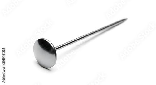 A single silver metal push pin with a flat round head and a sharp needle point, isolated on a white background, for office and, notice use