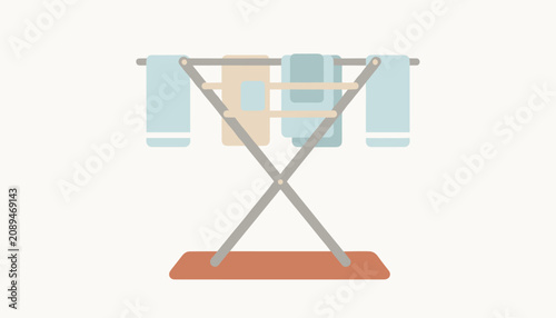 Wooden folding clothes drying rack with blue and beige towels hanging to dry over a simple mat on a neutral background.