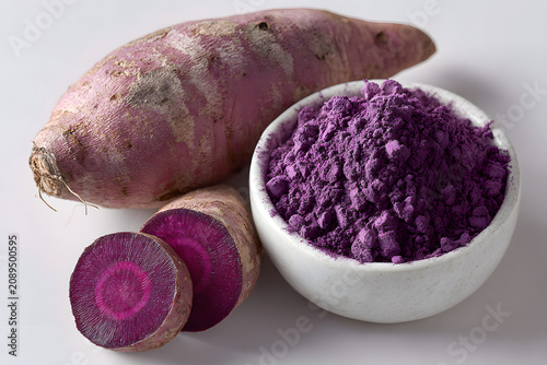 Ube (Filipino purple yam) powder in a bowl, sliced raw purple potato roots, tubers. Used for adding vanilla-nutty flavor to foods. rich in antioxidants  