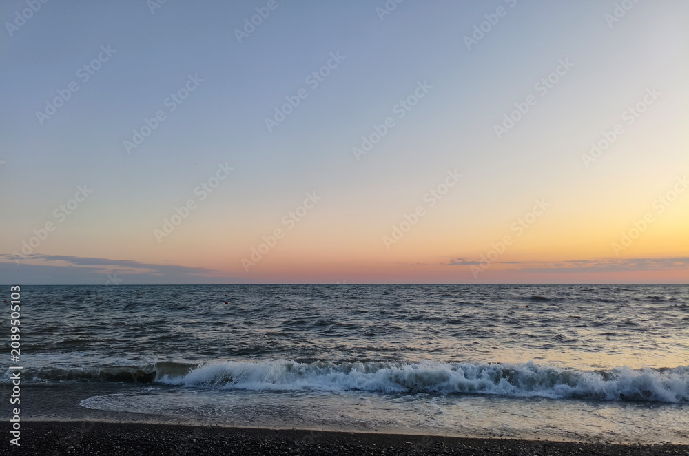 Obraz premium Summer sunset over the sea, the sun sinking below the horizon