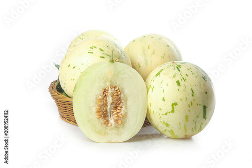 Fresh White Honeydew Melons with Green Stripes in Wicker Basket on White Background