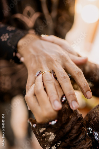 Two hands holding golden wedding rings in elegant gesture