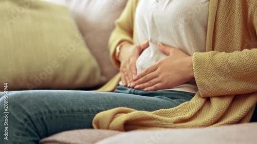 Woman holding her stomach due to abdominal pain, digestive discomfort, or gastrointestinal problem.