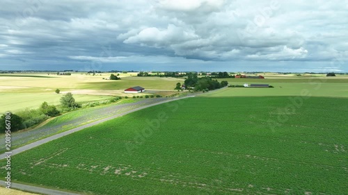 Aerial view flying over lush green farmland fields