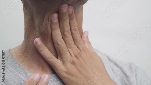 Man touching his throat due to sore throat, pain, or thyroid discomfort.