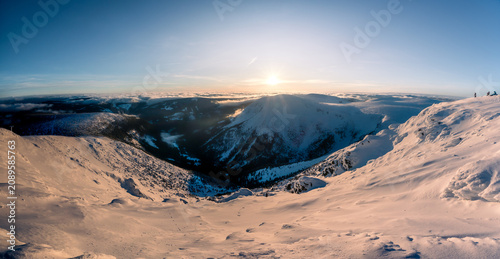 Panoramic winter view of deep mountain valleys fading into twilight dusk, Krkonose National Park.