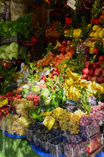 Принти на полотні A vibrant, densely packed outdoor market stall showcases a large variety of seasonal fruits and greens