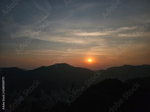 A serene landscape at sunset, showcasing silhouetted mountains against a colorful sky, evoking a peaceful and tranquil mood perfect for nature lovers and photographers.