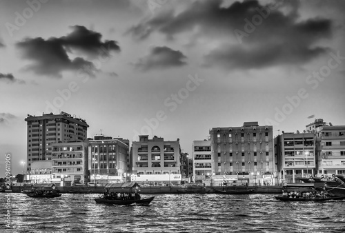 Foto Picturesque Bur Dubai waterway scene featuring dhow boats and vibrant sunset sky
