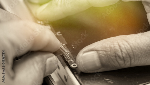 Konstfotografi Professional electronics repair specialist removing damaged port with solder wic