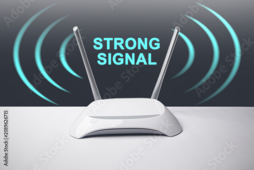 Картината върху платно A conceptual image featuring a minimalist white wireless internet router with two antennas, surrounded by glowing blue signal waves and the overlay text STRONG SIGNAL