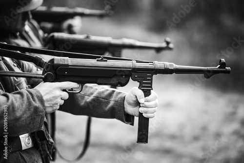 Quadro su tela Black and white photo of Wehrmacht soldiers in a firing line