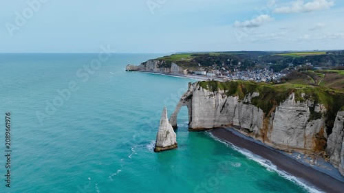 Etretat chalk cliffs and natural arch on Normandy coastline, France. Drone footage of French seaside landmark