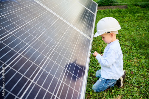 Fotografie Boy tightening solar panel with tool