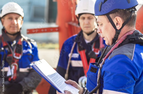 Quadro su tela A group of workers in safety gear reviewing safety procedures outdoors